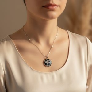 Pendentif rond en pierre naturelle obsidienne flocon de neige sur une chaîne maille fine en acier inoxydable argenté.